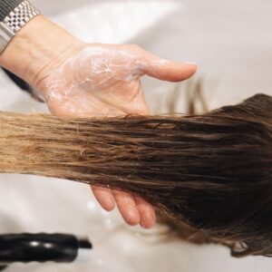 Close-up of a professional hair wash in a salon setting, highlighting hand technique.